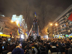 Protestētāji Ļeņina pieminekļa vietā uzvilkuši Ukrainas karogu. Foto: AFP/LETA