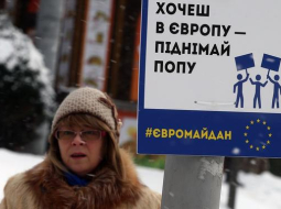 Protestētāja Kijevā, Neatkarības laukumā, aicina Eiropas atbalstītājiem būt aktīviem - "Gribi uz Eiropu - pecel pakaļu!". Foto: ITAR-TASS/LETA