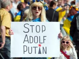 Ukrainas neatkarību atbalstoša demonstrante Vācijas pilsētā Frankfurtē pie Mainas rokās tur plakātu ar uzrakstu: "Stop Adolf Putin". Foto: EPA/LETA