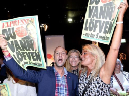 Zviedrijas sociāldemokrātu atbalstītāji līksmo par uzvaru vēlēšanās, rādot "dzeltenās" vakara avīzes "Expressen" vāku, kurā pausts atbalsts Stēfanam Levēnam. Foto: AFP/LETA