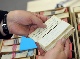 Dainu skapja atvilknes ar latviešu folklorista Krišjāņa Barona savāktajām latviešu tautasdziesmu kartēm Latvijas Nacionālo bibliotēkas ēkā "Gaismas pils". Foto: Ieva Lūka, LETA