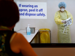 Kā rīkoties, saskaroties ar Ebolas vīrusa nēsātāju? Veselības darbiniece skatās video Manilā ar drošības instrukciju. Foto: AFP/LETA