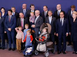 Eiropas valstu līderi un EP prezidents Hermanis van Rompejs pozē kopā ar bērniem pēc vienošanās. Foto: AFP/LETA