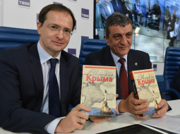 Krievijas kultūras ministrs Vladimirs Medinskis (no kreisās) un okupētās Sevastopoles gubernators Sergejs Meņailo ar pārrakstīto Krimas vēstures grāmatu. Foto: ITAR-TASS/LETA