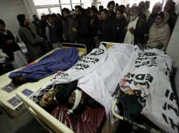 Vecāki un glābēji pie islāmistu uzbrukumā skolai Pakistānā nogalināto jauniešu mirstīgajām atliekām. Foto: EPA/LETA