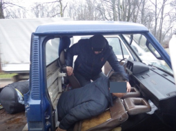 Nelegālie imigranti tiek izvilkti no slēptuves automašīnas grīdā. Foto: Valsts robežsardze/Delfi