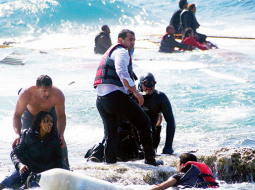 Grieķu glābšanas dienesti palīdz krastā izkļūt imigrantiem, kad pirmdien pie Rodas salas uz sēkļa uzskrēja un nogrima cilvēku kontrabandistu kuteris. 80 imigrantiem izdevās izglābties, bet trīs, ieskaitot vienu bērnu, noslīka