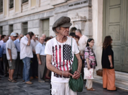 Cilvēki gaida Atēnās, kad atvērsies Grieķijas Nacionālās bankas durvis. Foto: AFP/LETA