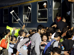 Pēc varas iestāžu atļaujas bēgļi traucas ieņemt vietas vilcienos. Foto: AFP/LETA