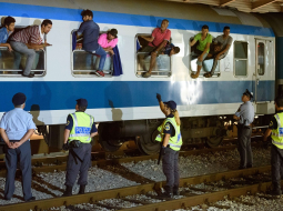 Patvēruma meklētāji vilciena logos sakliedzas ar policistiem un robežsargiem uz Slovēnijas-Horvātijas robežas Dobovas dzelzceļa stacijā. Slovēnija ceturtdien apturēja dzelzceļa satiksmi ar Horvātiju. Foto: AFP/LETA