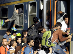 Sīriešu bēgļi laužas vilcienā, kam jādodas uz Austriju, Budapeštas dzelzceļa stacijā. Foto: AFP/LETA