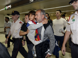 Sīrijas bēgli Osamu Abdulu Mohasenu al Ghadabu un viņa dēlu Zaidu Barselonas dzelzceļa stacijā sagaida Spānijas imigrācijas dienesta pārstāvji. Foto: AFP/LETA