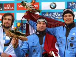 Uz pjedestāla Martins Dukurs (centrā), Tomass Dukurs un krievu sportists Aleksandrs Tretjakovs. Foto: EPA/LETA