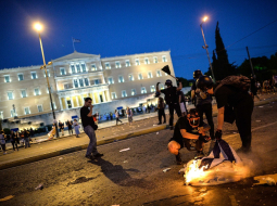 Protestētāji pie Grieķijas parlamenta ēkas Atēnās pagājušajā naktī, kad apsprieda reformu plānu. Foto: AFP/LETA