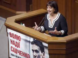 Ukrainas finanšu ministre Natālija Jaresko uzstājas parlamentā. Tribīnei piestiprināts plakāts, kas aicina atbrīvot Ukrainas lidotāju Nadeždu Savčenko. Foto: AFP/LETA
