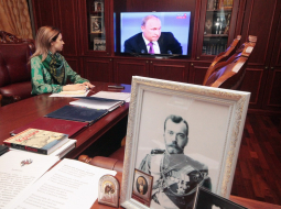 Kas ir prokurores galvā? Krimas ar pret Ukrainu vērstām apsūdzībām bēdīgi pazīstamā prokurore Natālija Poklonska decembrī TV vēro prezidenta Putina uzstāšanos, bet viņas darba kabinetā uz galda liels cara Nikolaja II portrets. Foto: ITAR-TASS/LETA
