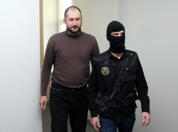 Viens no aizturētajiem Krievijas pilsoņiem Aleksandrs Kurkins, kurš nelikumīgi bija iekļuvis Ādažu militārajā bāzē un pie kura atrastas skrejlapas angļu valodā, tiek konvojēts uz Rīgas pilsētas Vidzemes priekšpilsētas tiesas sēdi, kurā lems par drošibas līdzekļa piemērošanu. Foto: Ieva Čīka, LETA