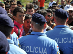 Policisti Horvātijas austrumos pie Tovarnikas apturējuši migrantus un bēgļus, kad tie pameta dzelzceļa staciju, lai dotos uz Zagrebu. Foto: EPA/LETA