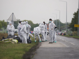 Brīvprātīgie aizsardzības tērpos savāc atkritumus, kas palikuši pēc migrantiem, kad tie šķērsoja Serbijas un Horvātijas robežu. Foto: EPA/LETA