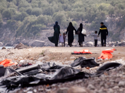 Migrantu ģimene Lesbos salā Grieķijā pēc ierašanās no Turcijas puses aiz sevis atstāj pamestas glābšanas vestes un dodas tālāk. Foto: AFP/LETA