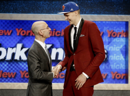 Latviešu basketbolists Kristaps Porziņģis (no labās) Nacionālās basketbola asociācijas (NBA) drafta ceremonijā pasniedz roku līgas komisāram Adamam Silveram. Foto: EPA/LETA