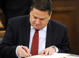 Dzintars Zaķis paraksta 12.Saeimas deputāta zvērestu. Foto: Edijs Pālens, LETA