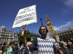 Protesta akcijā Londonā vīrietis tur plakātu ar uzrakstu: "Mēs visi esam imigranti." Foto: AFP/LETA