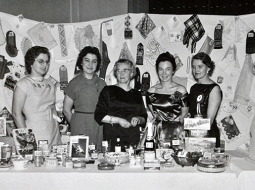 1958. gads, Bredfordas Daugavas vanadžu komiteja pie gadskārtējās loterijas galda, kurā varēja vinnēt arī pašu darinātus gardumus un tautiskus rokdarbus
