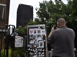 ''Grenfell Tower'' ugunsgrēkā pazudušo cilvēku fotogrāfijas pie nodegušās ēkas. Foto: Reuters-LETA