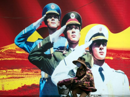 Ķīnas militārās propagandas plakāts Šanhajas ielā. Foto: AFP/LETA