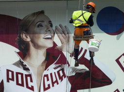 Krievijas sportiste Tatjana Navka tērpusies olimpiskās izlases apģērbā lielā plakātā Krievijas olimpiskās komitejas logā. Foto: AP/LETA