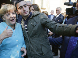 Angela Merkele un Anass Modamani bēgļu izmitināšanas centrā Berlīnē 2015. gada septembrī.