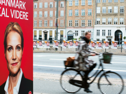 Sociāldemokrātu partijas līdere (un pašreizējā premjere) Helle Torninga–Šmita ar saukli «Dānijai jādodas tālāk» priekšvēlēšanu plakātā 2011.gadā. Daudzus pārsteidzis fakts, ka tieši kreisi noskaņotā valdība ķērusies pie dāsnās labklājības sistēmas pārskatīšanas.