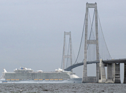 Svētdien bēguma laikā Somijā būvētajam pasažieru lainerim Allure of the Seas izdevās izspraukties zem tilta starp Kopenhāgenu un Malmi — atstarpe starp kuģa augstāko torni un tilta vēdera augstāko daļu bija tikai 51 cm. Foto — LETA/AFP