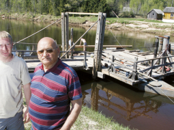 Laimonis Gradovskis (pa labi) atnācis apraudzīt uzbrauktuves remontdarbus, ko pēc negaidītajiem pagājušā rudens plūdiem un šāpavasara paliem veic jaunais pārcēlājs, viņa dēls Mareks. Līgatnes prāmis darbu atsāka šonedēļ. Foto — Mārtiņš Zilgalvis, F64