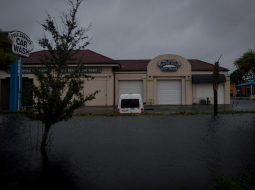 Plūdu ūdens ieskauj automašīnu mazgātavu Floridā, Bonita Springs.