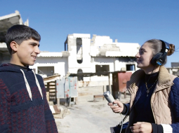 Kadrs no Radio Kobane. 20 gadus vecā Dilovana Kiko vada radio pārraides smagi izpostītajā  Sīrijas pilsētiņā Kobanē.