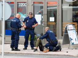 Turku policisti pie viena no sadurtajiem cilvēkiem. Foto: AFP/LETA