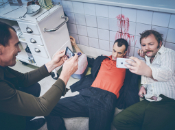 Amizants brīdis filmēšanas laukumā — aktieri sevi iemūžina neikdienišķi asiņainos pašģīmjos.
Foto — Lauris Vīksne