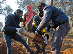 Civilās aizsardzības vīri pārvieto Sīrijas armijas izšauto lādiņu ar, iespējams, ķīmiskām vielām. Šādus lādiņus Asada armija izmantoja uzbrukumā Austrumgutas pilsētai Doumai, kur trīs cilvēki mira no respiratorām problēmām. Foto: AFP/LETA