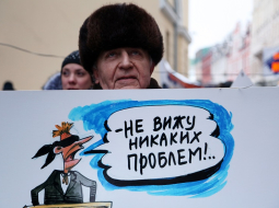 "Neredzu nekādu problēmu," vēsta uzraksts karikatūrā, kuru tur pret izglītību latviešu valodā noskaņots piketētājs pie Saeimas ēkas. Foto: Edijs Pālens, LETA