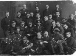 Valmieras reālskolas skolnieki. 1919. gada maijs. Centrā skolas direktors Ludis Adamovičs, viņam priekšā 1. rindā Alfrēds Lukstiņš.
Foto no Latvijas Kara muzeja krājuma