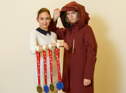 «Introvertais latvietis,» ar šādu neoficiālu nosaukumu lietusmētelim, kas Eiropas jauniešu amata prasmju konkursā ieguva 1. vietu, nāk klajā autores Laura (no labās) un Elīna. 
Latvijas komandā bija 12 dalībnieki ar 10 dažādām profesijām, veiksmīgās tērpu modelētājas Ungārijā saņēma arī medaļas Labākais nācijā.
Foto — Gints Ivuškāns