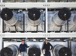 Climeworks līdzdibinātāji Kristofs Gebalds (pa kreisi) un Jans Vircbahers pie gaisa pārtveršanas rotoriem uz rūpnīcas jumta Hinvilas ciemā Šveicē.
Foto — The New York Times