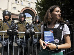 Olga Misika ar Krievijas konstitūciju pie omoniešu barjeras 27. jūlijā  protestā Maskavā.
Foto — Sputnik/Scanpix