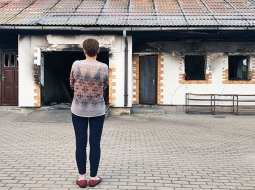 Jeļena pie savas izdegušās mājas Krāslavā. Pēc meitas nogalināšanas uguni ēkai pielaida Jeļenas vīrs, kas pēc tam pakārās.
Foto — Inese Liepiņa
