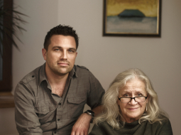 Lelde Kalmīte un Kārlis Kanderovskis Cēsu dzīvoklī. Fonā viena no Jāņa Kalmītes slavenajām rijām, kuru skaits mērāms simtos, bet varbūt pat tūkstošos.
Foto — Reinis Hofmanis