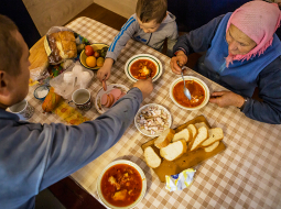 Ukrainiete Olha Habro ar dēlu un mazdēlu pusdienas sāk ar pašas gatavotu boršču.
Foto — The New York Times