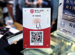 Cenu zīme kādā Ķīnas veikalā ar digitālās valūtas QR kodu