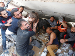 Glābēji pēc Izraēlas apšaudes 16. maijā izglābj no sagrautas ēkas drupām kādu meitenīti Gazas joslā.
Foto — Scanpix